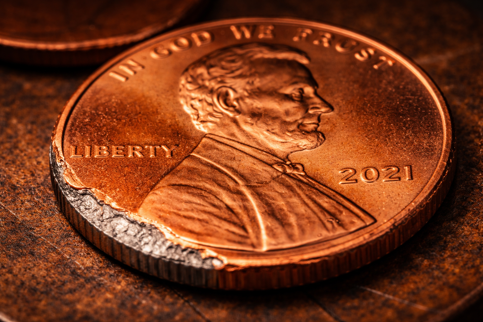 Modern zinc penny with copper plating revealing inner zinc core